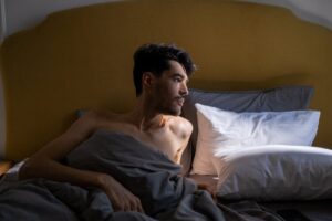 A person waking up feeling fresh and rested with morning sunlight on their face